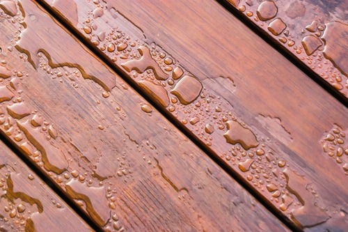 Pooled water on finished deck with woodgrain